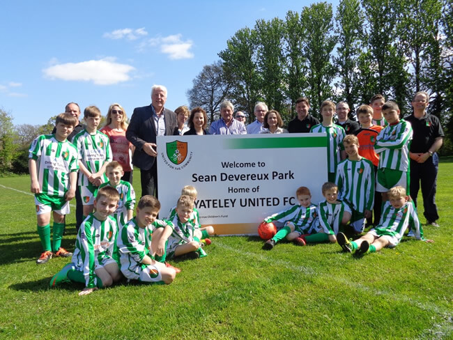 Photo of Yateley United FC Youth players next to a Sean Devereux Park sign